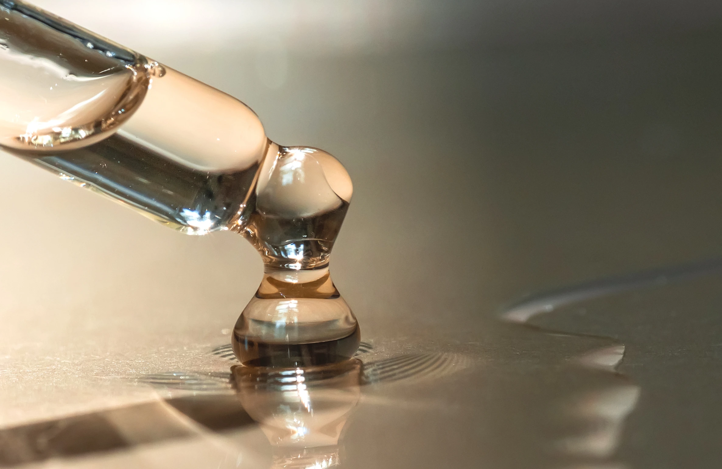 Close-up of a serum dropper releasing liquid, representing skincare treatments like Skin Boosters in Himayat Nagar.